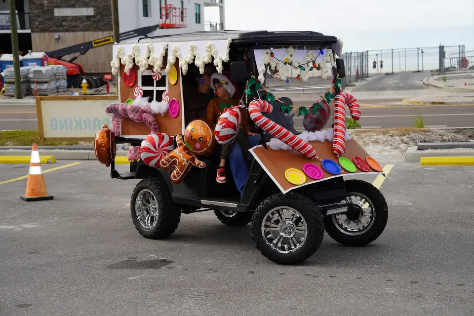 Golf cart decorated as a gingerbread house with candy canes, parked in the lineup lot